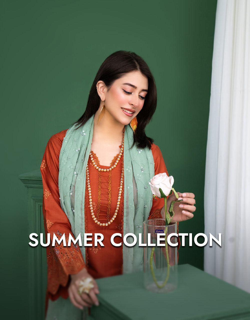 Woman holding a flower in a green room with 'Summer Collection' text