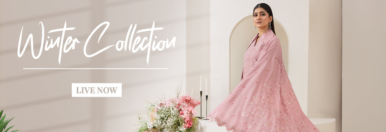 Woman in a pink suit with floral decorations and 'Winter Collection Live Now' text.